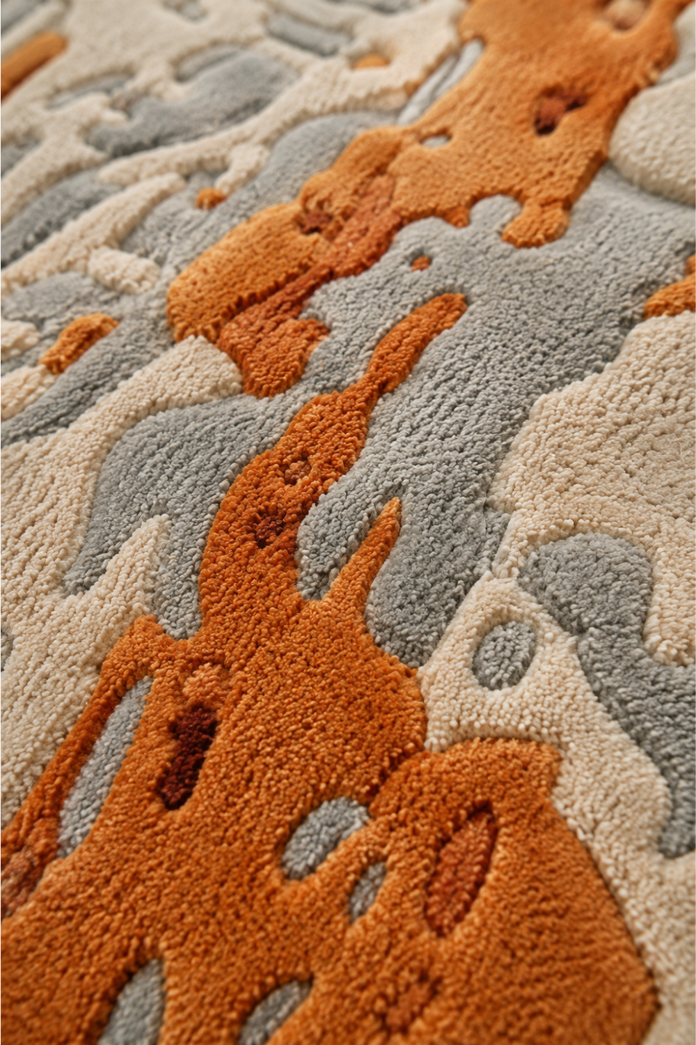 Close-up of Amber Drift rug showing raised hand-tufted pile, tactile texture and layered terracotta, ivory and grey abstract detailing