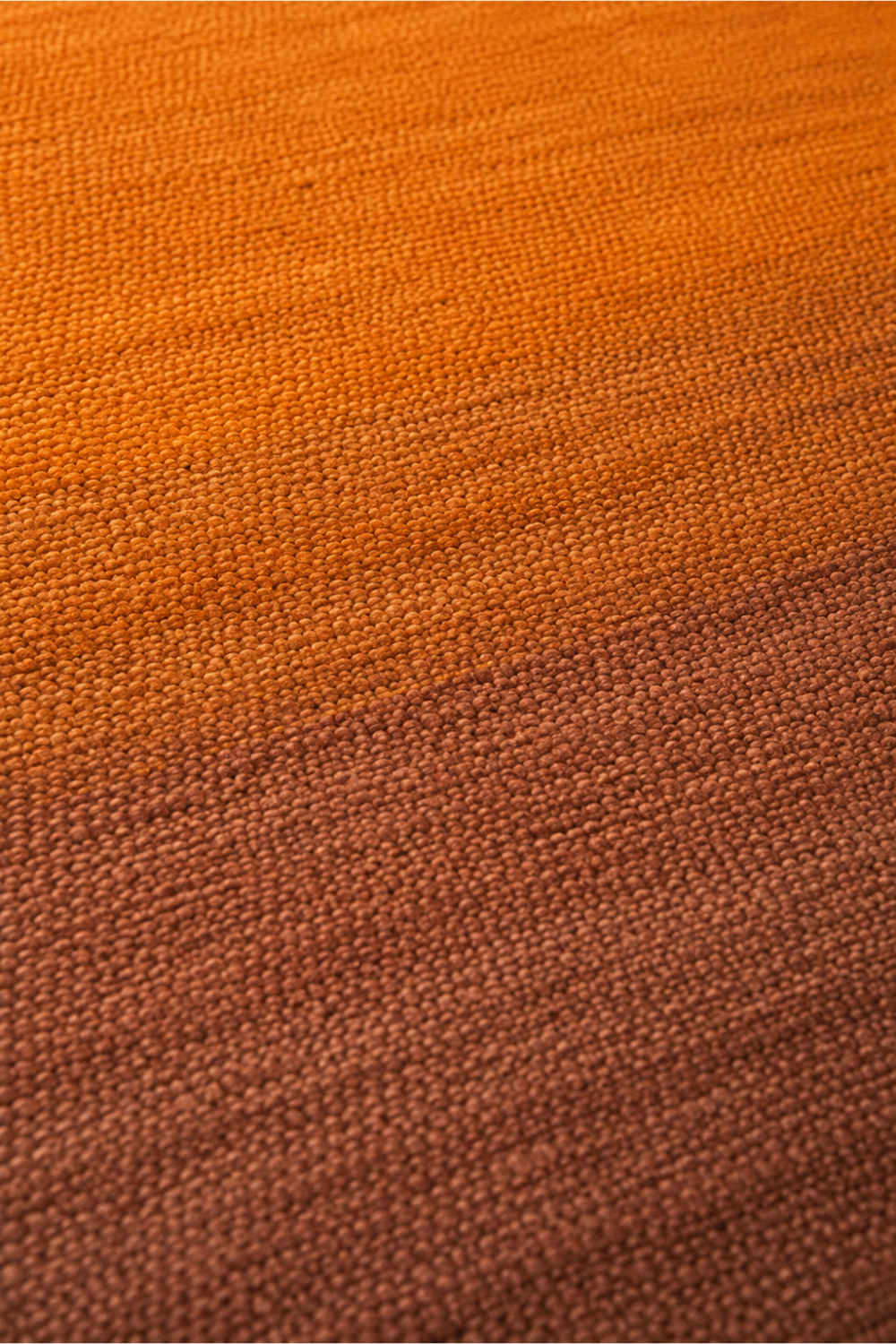 Close-up of the Amber Ember handloom New Zealand wool rug showcasing premium wool texture and handcrafted burnt orange gradient weave