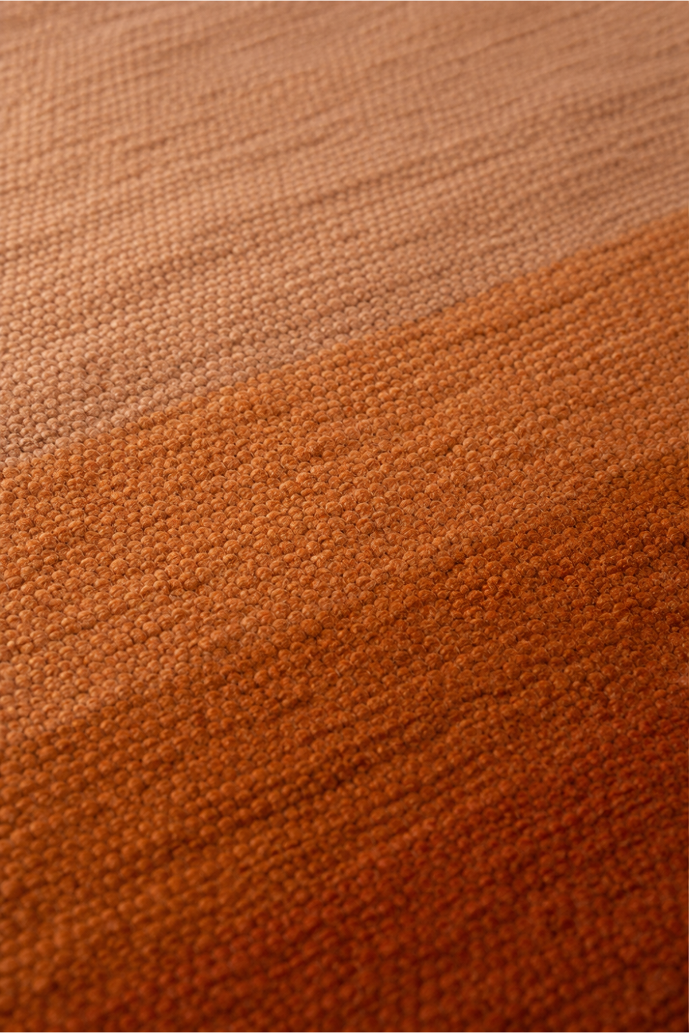 Close-up of the Amber Horizon handloom New Zealand wool rug showcasing handcrafted texture, soft ombre shading and rich terracotta colour transitions