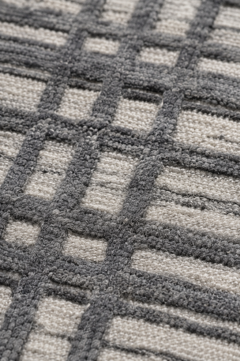 Close-up of the Ash Grid handloom wool and viscose rug showcasing raised grey linear detailing, woven texture and artisan craftsmanship
