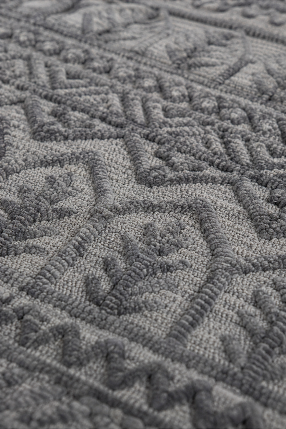 Close-up of the Ash Heritage handloom over hand tufted New Zealand wool rug showcasing raised carved tribal motifs and handcrafted wool texture