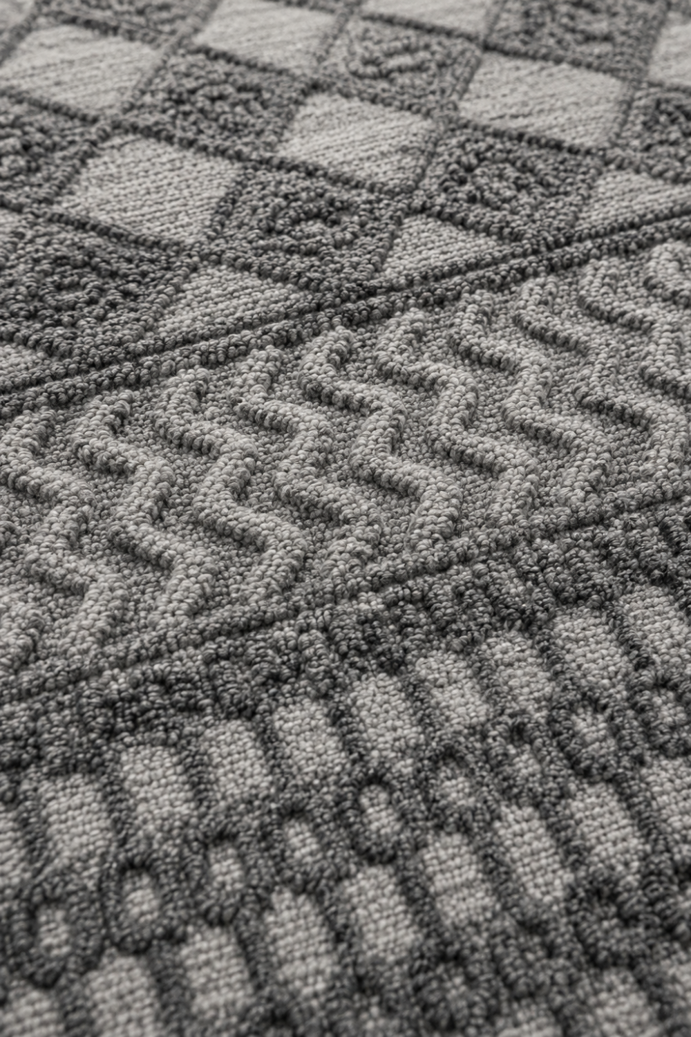 Close-up of the Atlas Rhythm handloom over hand tufted New Zealand wool rug showcasing raised geometric carving and handcrafted wool texture