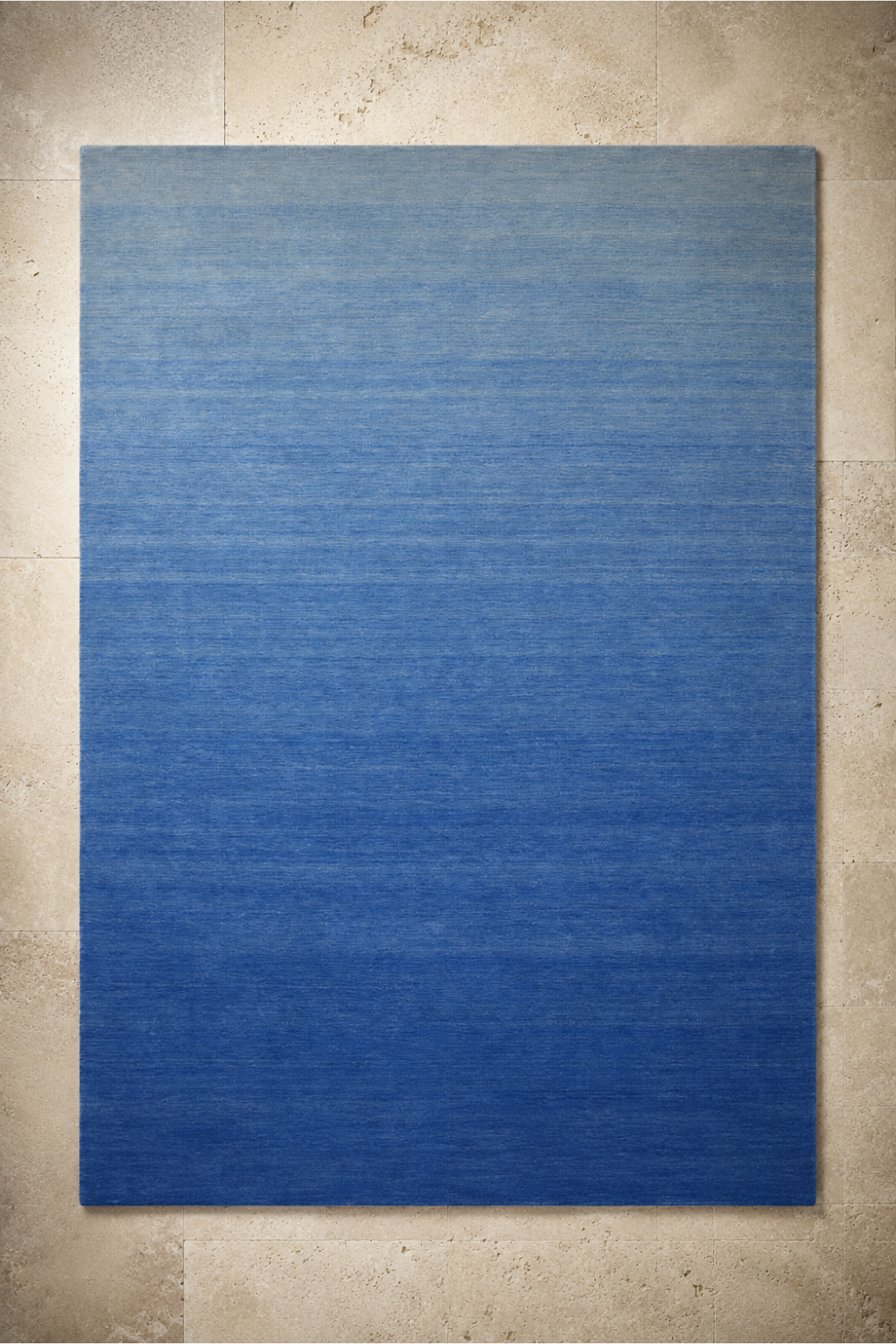 Azure Horizon handloom New Zealand wool blue gradient rectangular area rug on a neutral stone background