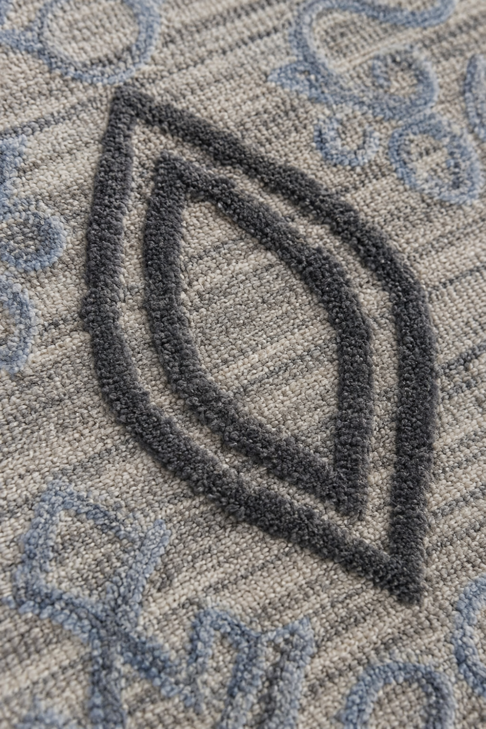 Close-up of the Azure Nomad handloom over hand tufted New Zealand wool rug highlighting raised blue grey diamond motifs and handcrafted texture