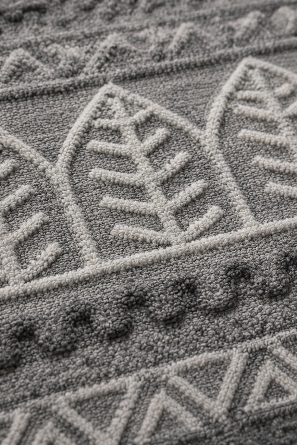 Close-up of the Botanical Rhythm handloom over hand tufted New Zealand wool rug highlighting raised botanical leaf motifs and handcrafted carved texture