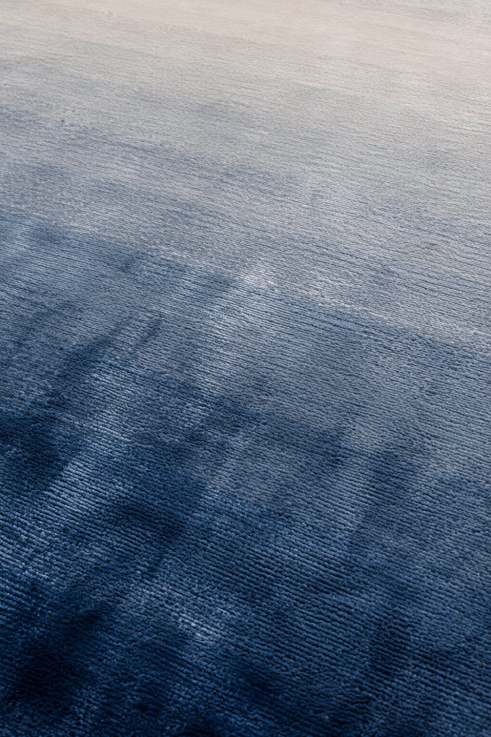 Close-up of the Celestial Tide handloom Tencel rug showcasing its blue ombre gradient, silky texture and handcrafted finish