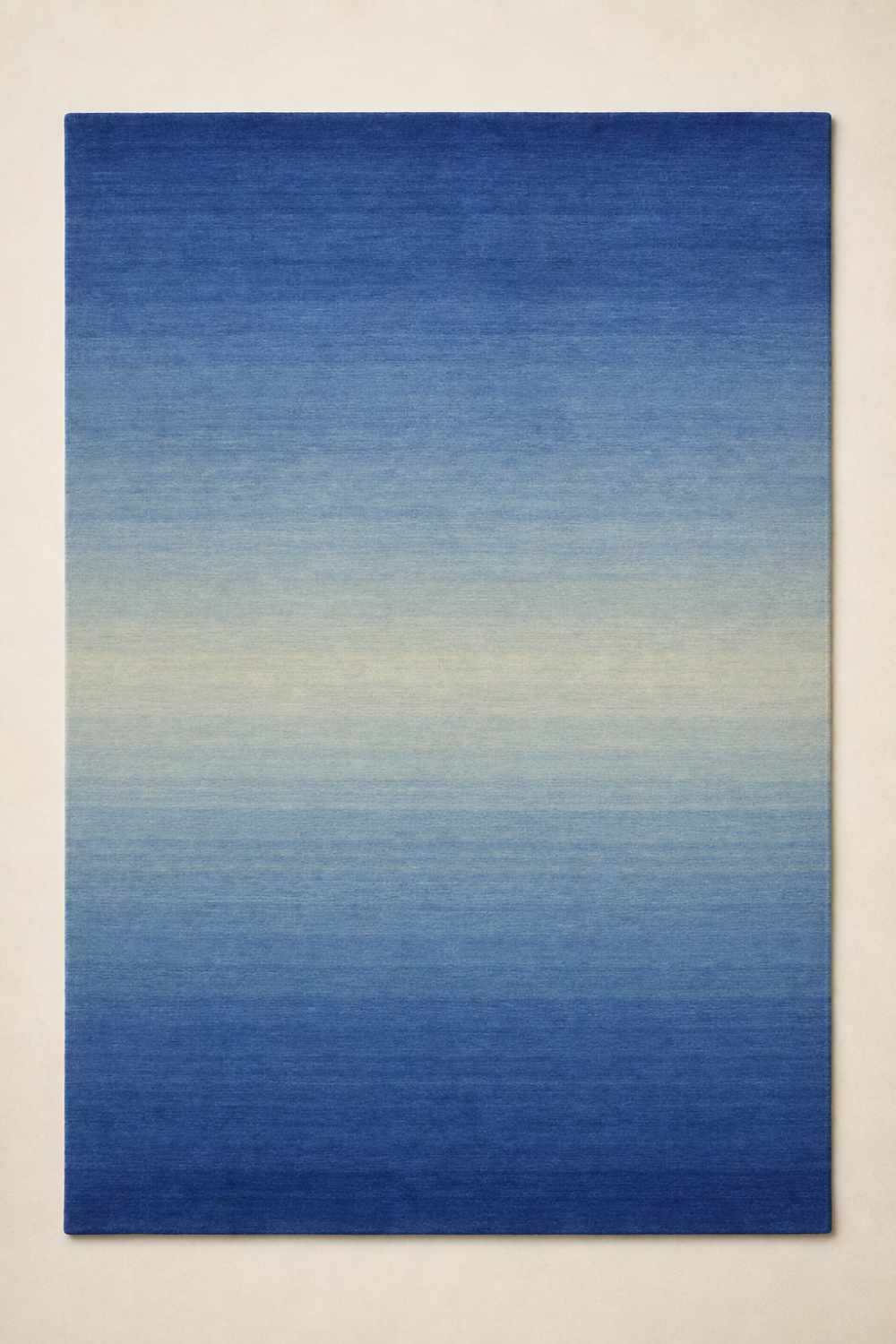 Cobalt Tide luxury handloom New Zealand wool blue ombre area rug styled in a contemporary coastal living room overlooking the ocean.