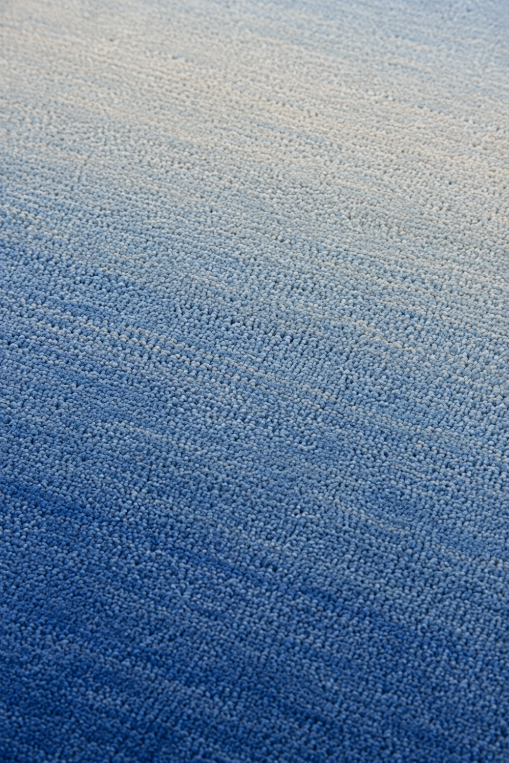 Close-up of the Cobalt Tide handloom New Zealand wool rug showcasing its blue ombre texture and handcrafted weave.