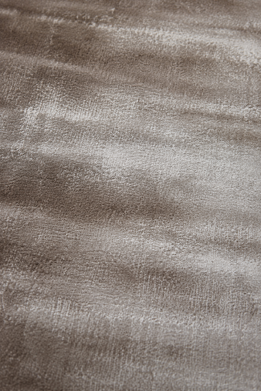Close-up of the Desert Veil Handloom Plain Viscose rug highlighting the handcrafted texture, warm taupe fibres and subtle tonal variation.