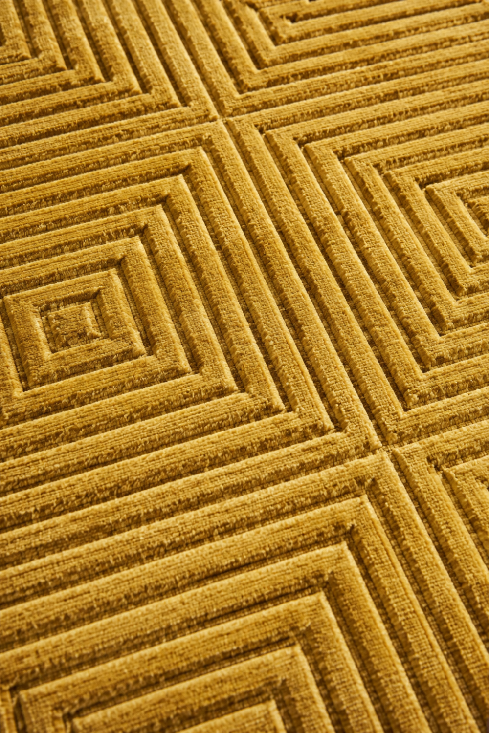 Close-up of the Golden Concentric Grid Rug highlighting the carved concentric square texture and premium Handloom Viscose Tencel Bamboo craftsmanship.