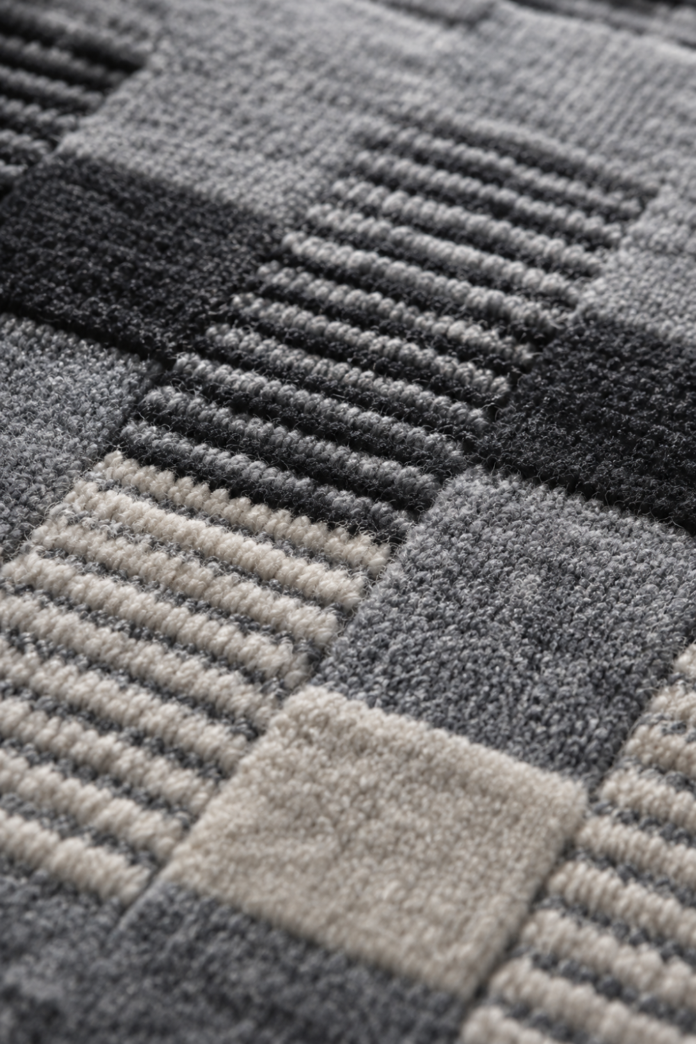 Close-up of the Metro Mosaic handloom wool and viscose rug showcasing raised geometric blocks, ribbed weave texture, and handcrafted detailing