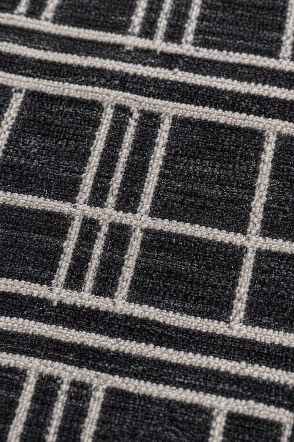 Close-up of the Midnight Lattice handloom wool and viscose rug showcasing raised ivory linear detailing, premium woven texture and artisan craftsmanship