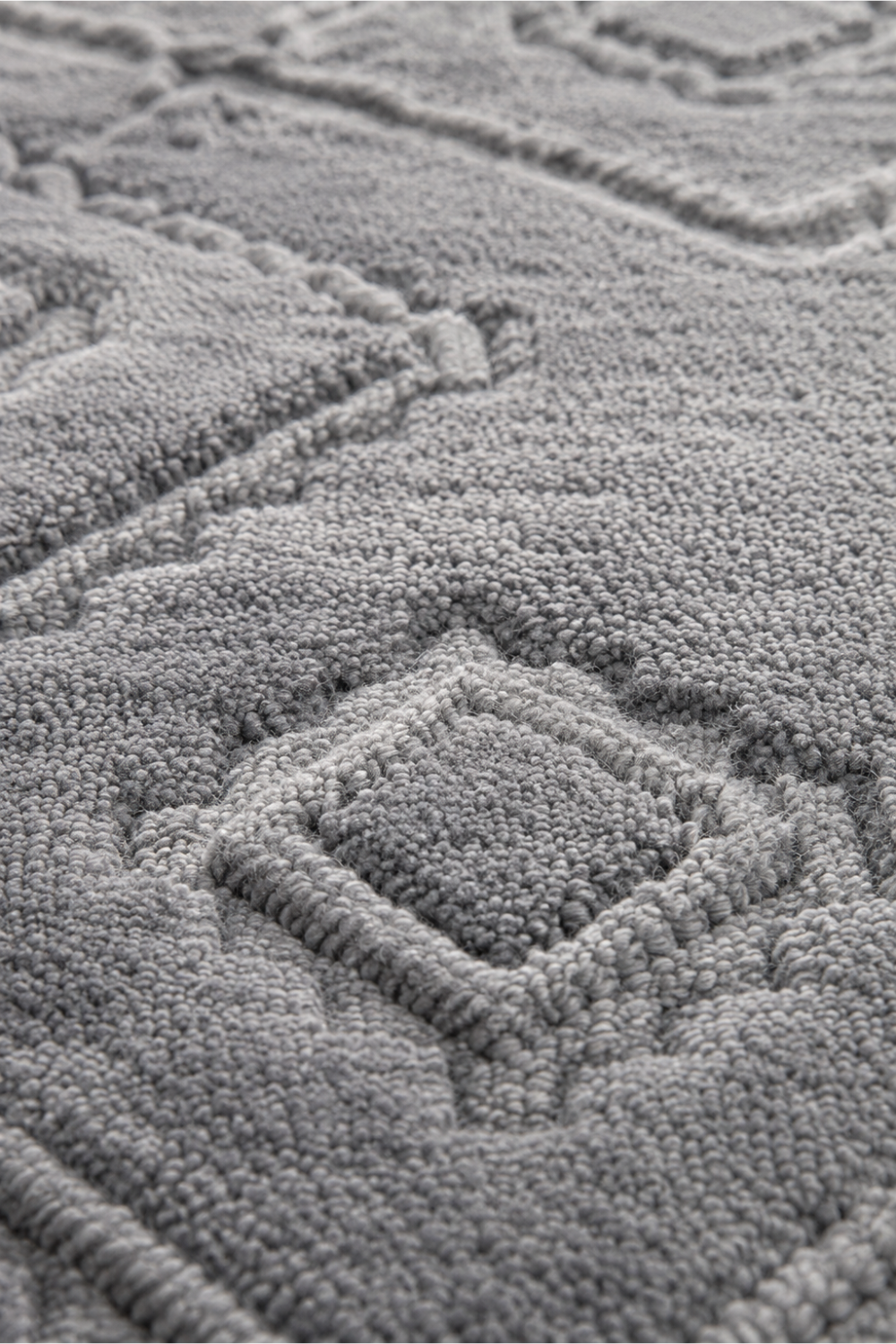 Close-up of the Mist Haven handloom over hand tufted New Zealand wool rug showcasing raised carved diamond motifs and handcrafted wool texture