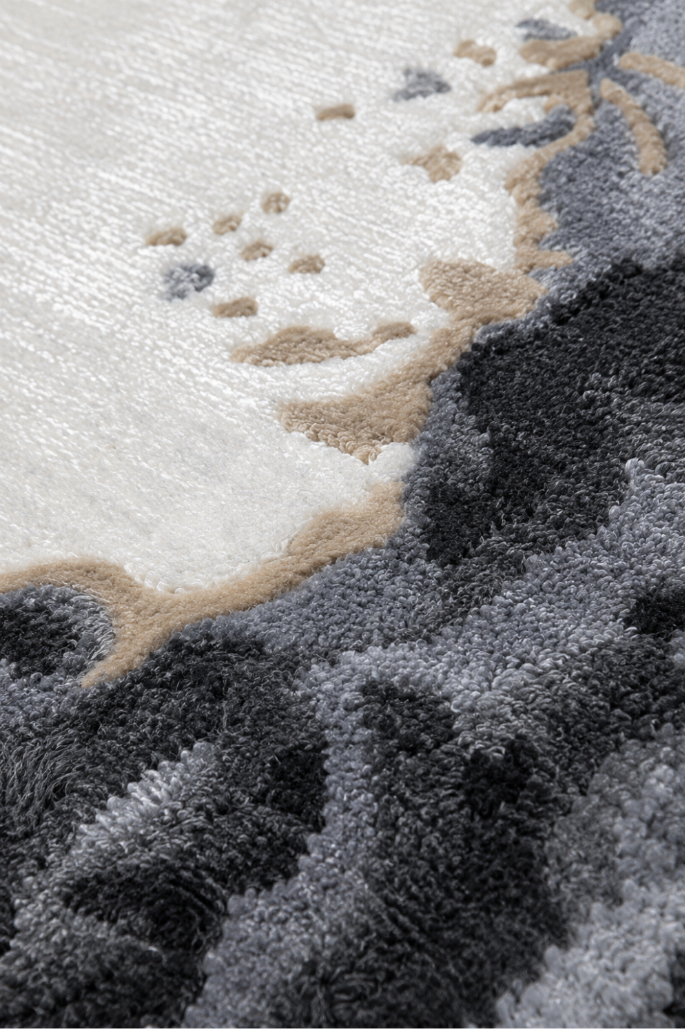 Close-up texture of the Obsidian Halo Round Rug showcasing its handcrafted high-low pile with ivory, charcoal, grey, and warm sand detailing.
