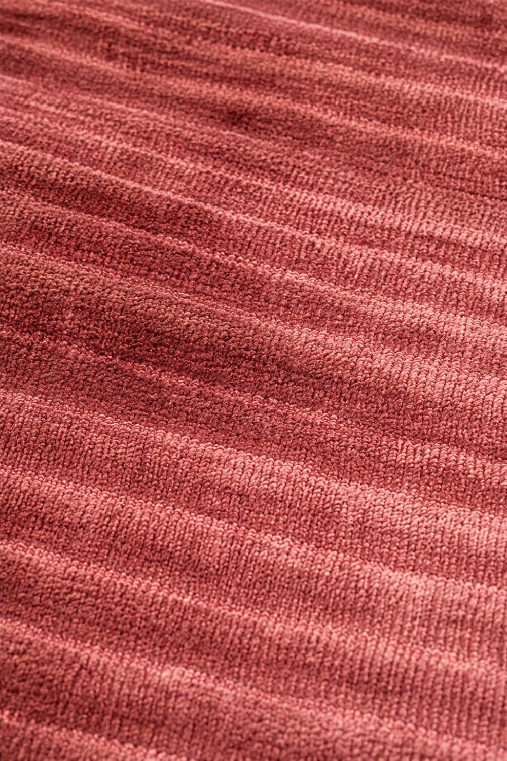 Close-up of the Rose Ember Handloom Plain Viscose rug highlighting the handcrafted ribbed weave, soft sheen and dusty rose fibres.