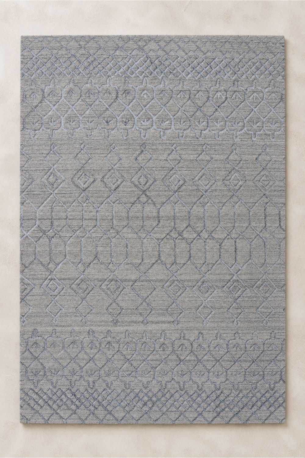 Silver Haven handcrafted handloom over hand tufted grey geometric New Zealand wool area rug with carved tribal pattern on a neutral background