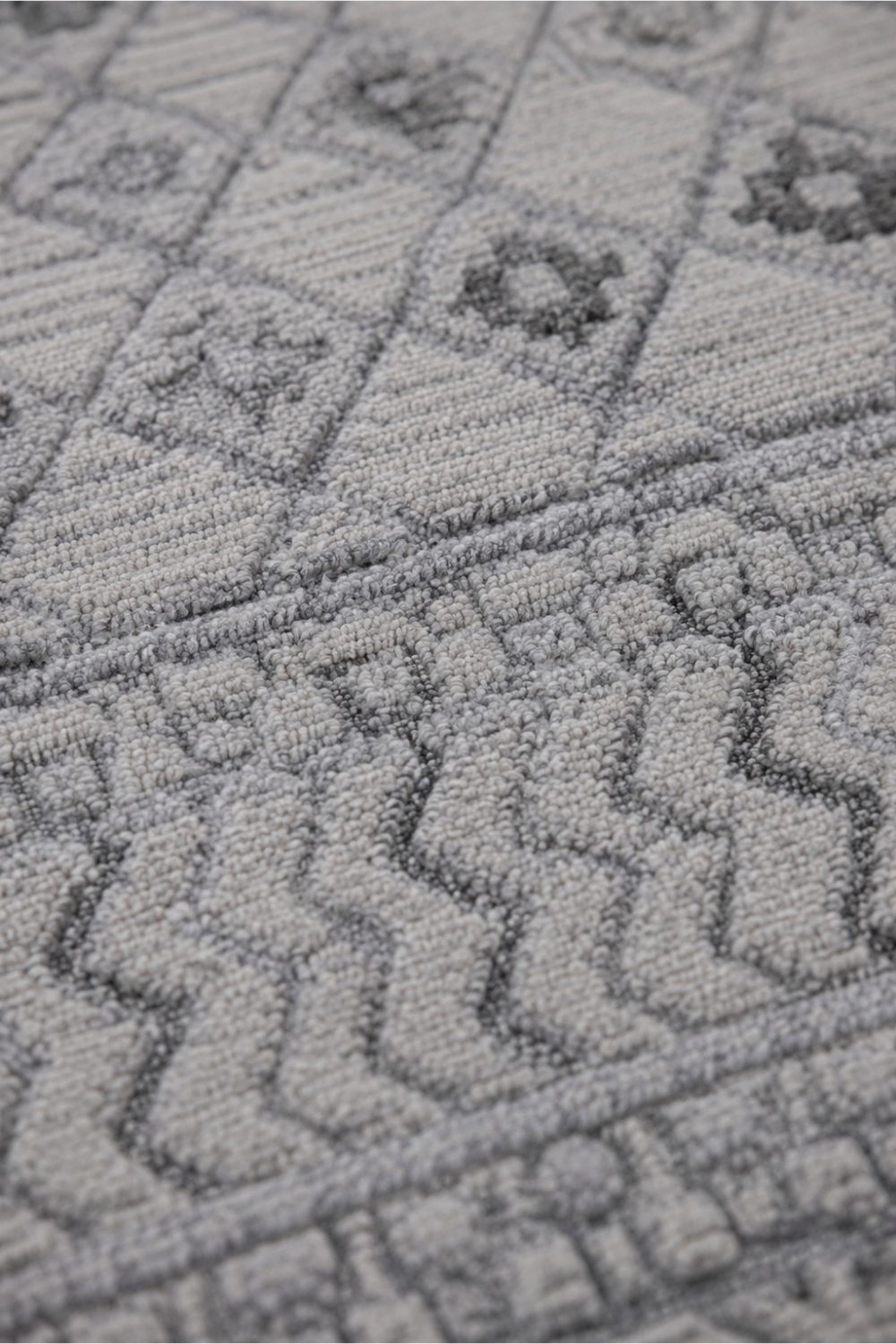 Close-up of the Silver Mosaic handloom over hand tufted New Zealand wool rug showcasing raised carved tribal geometric textures and handcrafted wool pile