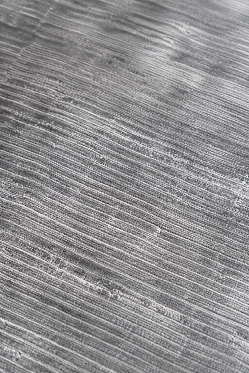 Close-up texture of the Silver Strata Handloom Plain Viscose rug showing handcrafted horizontal weave and subtle tonal detailing.