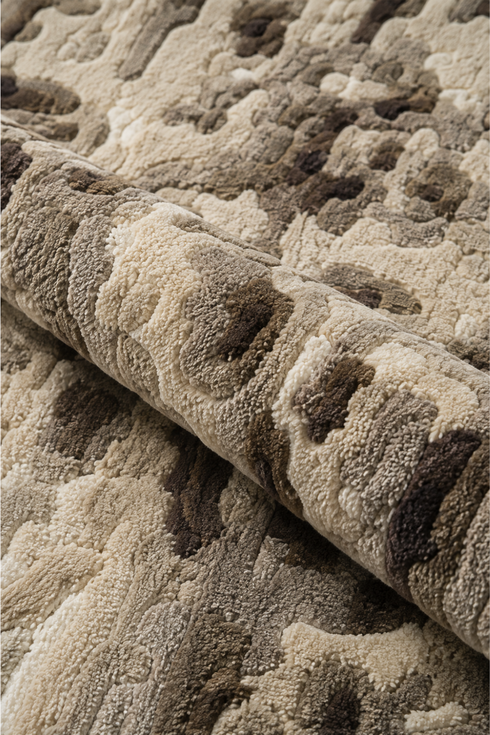 Close-up of Stone Terrain rug showing tactile hand-tufted pile and layered ivory, cream, taupe and brown abstract detailing
