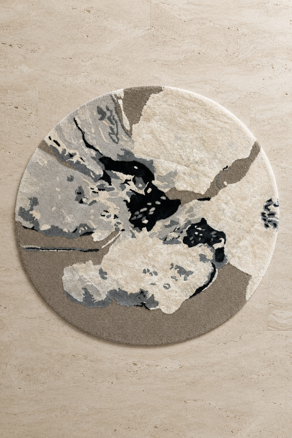 Stone Veil Round Rug featuring an organic abstract pattern in warm ivory, stone grey, taupe, and charcoal with a sculpted handcrafted texture.