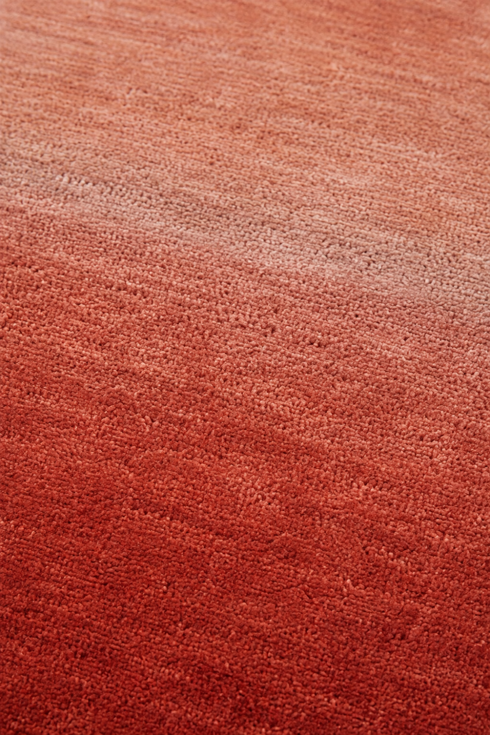 Close-up of the Terracotta Glow handloom New Zealand wool rug showcasing its terracotta ombre texture and handcrafted weave.