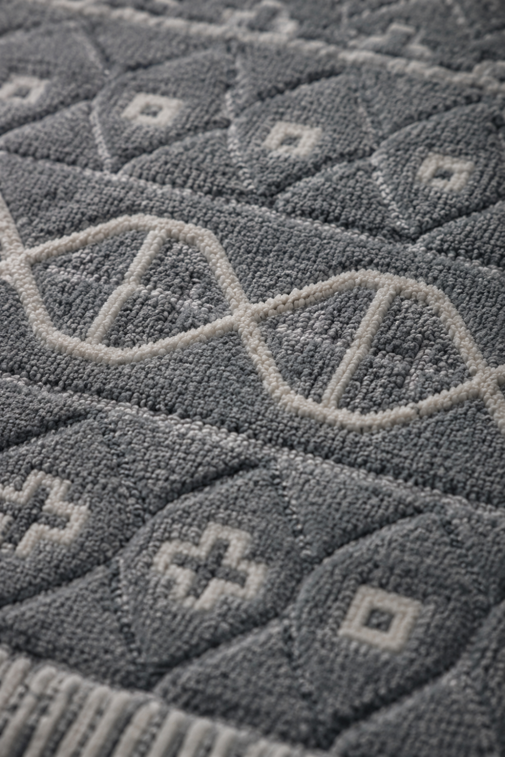 Close-up of the Tribal Harmony handloom New Zealand Wool rug highlighting carved tribal motifs and handcrafted texture